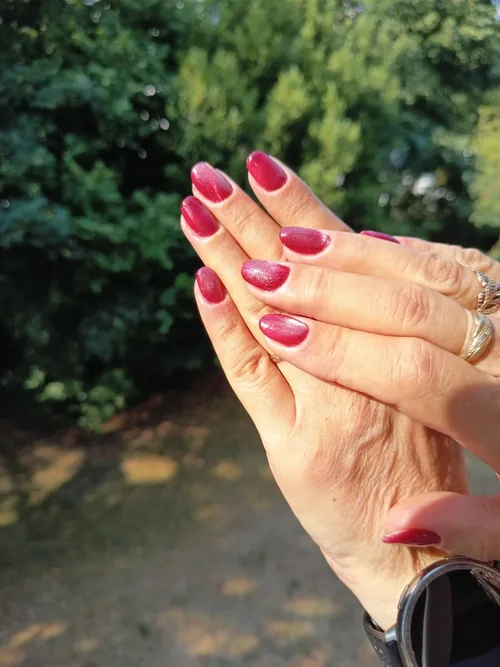 Pose gel rose framboise pailleté sur ongles amande, les deux mains
